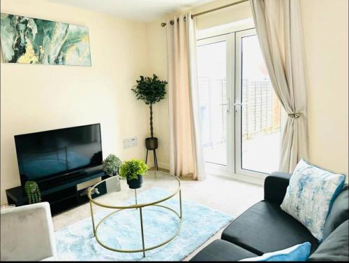 sala de estar con TV y mesa de cristal en New Build Luxury Home in Ashford, en Willesborough