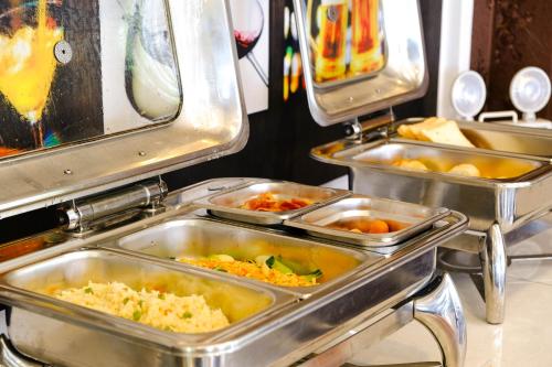 ein Buffet mit Tabletts voller Essen in der Unterkunft Paradise Hotel Hoi An in Hoi An