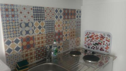 La salle de bains est pourvue d'un lavabo et d'un mur carrelé. dans l'établissement 1 Bedroom flat, on Metro7, direct Louvre, Parking,Wifi, à Aubervilliers