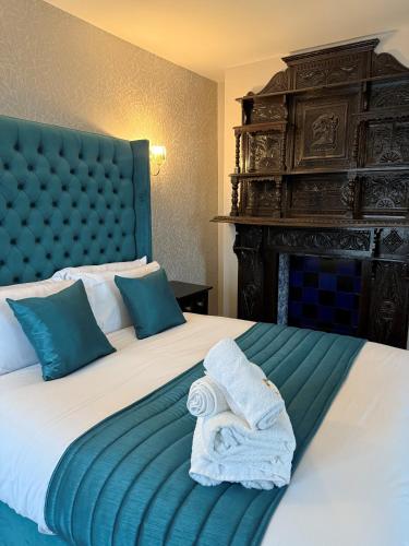 a hotel room with a bed with towels on it at Lyons Woodlands Hall in Ruthin