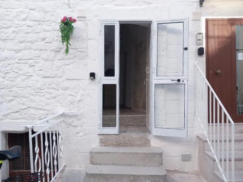 a white door with a plant on the side of a building at Le Bianche Suites Ostuni in Ostuni