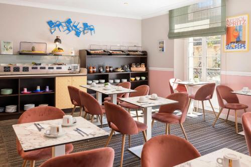 a restaurant with tables and chairs and a counter at Best Western Hotel Lakmi Nice in Nice