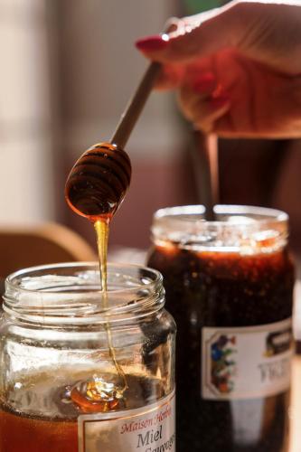 a person is pouring honey into a jar at Best Western Hotel Lakmi Nice in Nice