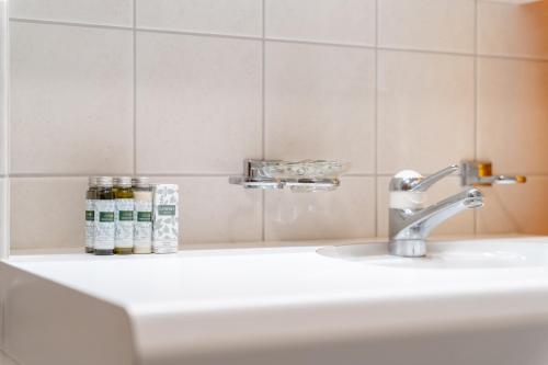a sink in a bathroom with a toothbrush holder at Chalet St Moritz in Madulain