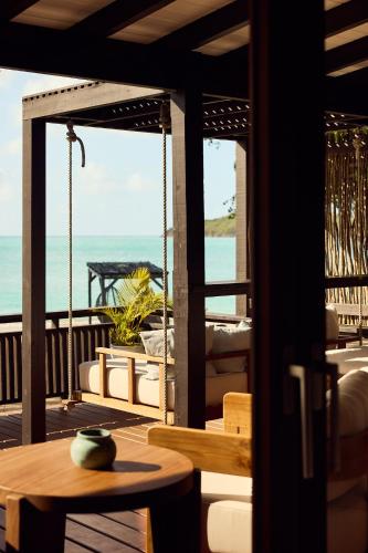 a balcony with a table and a view of the ocean at Hermitage Bay - All Inclusive in Saint Johnʼs
