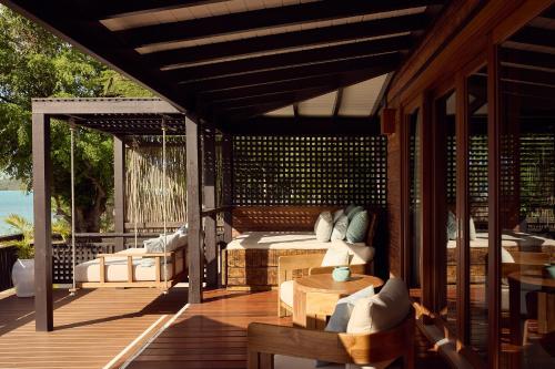 a patio with a couch and chairs on a deck at Hermitage Bay - All Inclusive in Saint Johnʼs