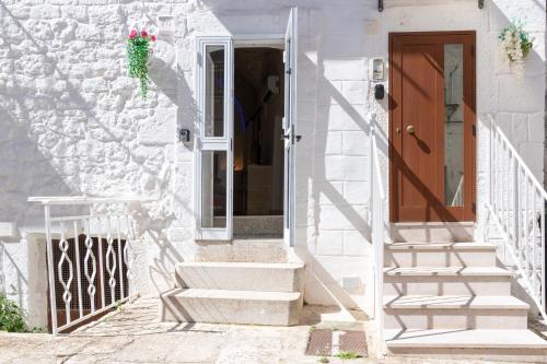 a white house with stairs leading to a door at Le Bianche Suites Ostuni in Ostuni