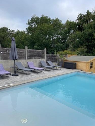 une piscine avec des chaises longues et un parasol dans l'établissement Villa familiale, à Le Fenouiller