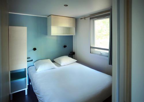a bedroom with two beds and a window at Camping de la Base Nautique in Saint-Rome-de-Tarn