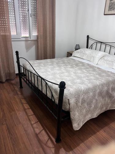 a bedroom with a black bed with a white comforter at Da Adriana Guesthouse in Santa Teresa Gallura