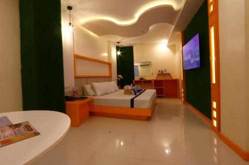 a bedroom with a bed and a television in it at Hotel Dreamworld East Ortigas in Manila