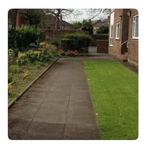 an empty sidewalk in front of a house at The Mansion Room in Manchester