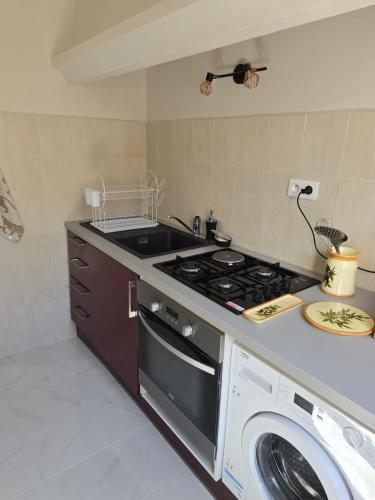 une cuisine avec une cuisinière et une machine à laver dans l'établissement Studio Celli l Near Port & AC l Shellter Rentals, à Saint-Tropez