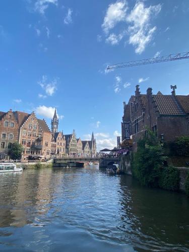 a river in a city with buildings and a bridge at B&B PETIT PRINCE, GENT in Ghent