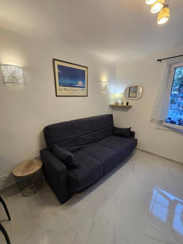 un salon avec un canapé noir dans une pièce dans l'établissement L'Alphonse l Near the Port l Shellter Rentals, à Saint-Tropez