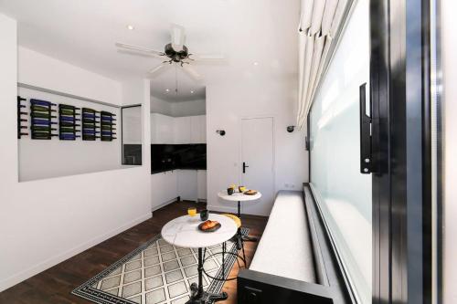 une chambre avec deux tables et un ventilateur de plafond dans l'établissement Appartement proche des celebres puces de Paris 4P, à Paris