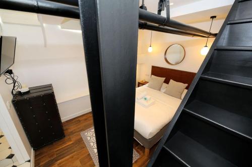 une petite chambre avec un lit et un miroir dans l'établissement Appartement proche des celebres puces de Paris 4P, à Paris
