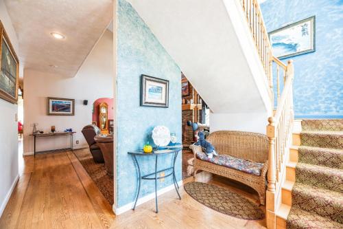 a living room with stairs and a blue wall at Coastal Getaway home in El Granada