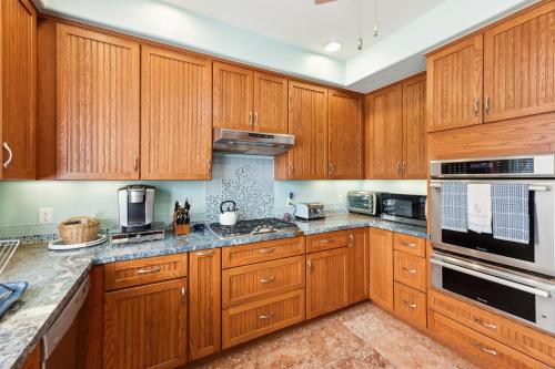 a kitchen with wooden cabinets and stainless steel appliances at Coastal Getaway home in El Granada