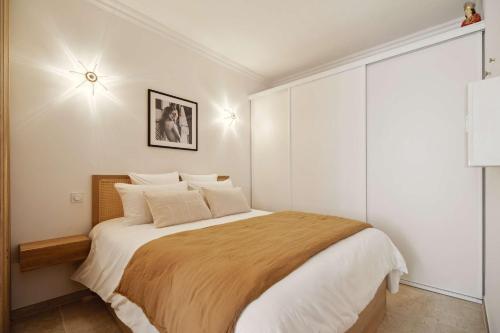 - une chambre avec un grand lit aux murs blancs dans l'établissement Petit Saint-Jean l Old Village l Shellter Rentals, à Saint-Tropez