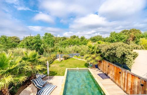 une cour arrière avec une piscine et une terrasse en bois dans l'établissement Villa 33 l Pool & Gym l Shellter Rentals, à Grimaud