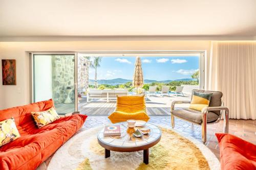 un salon avec un canapé et une table dans l'établissement Villa Palm Dreams l 70s Design l Shellter Rentals, à Grimaud