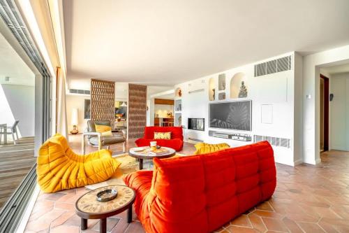 Il comprend un salon doté d'un mobilier rouge et d'une télévision. dans l'établissement Villa Palm Dreams l 70s Design l Shellter Rentals, à Grimaud