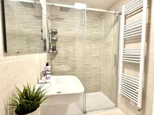 une salle de bain blanche avec une douche et un lavabo dans l'établissement Paradigm House, Luxury 2-Bedroom Apartment 3, Free Parking, Oxford, à Oxford