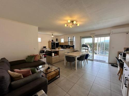 un salon avec un canapé et une table dans l'établissement Appartement Cardellina Jardin & Ville, à Calvi