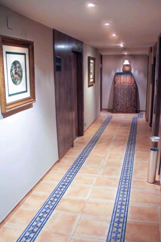 a hallway with a floor with blue and white tiles at Hotel Virrey in Arnedo