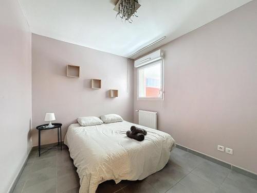 une chambre avec un lit avec un ours en peluche dessus dans l'établissement Le Grand Chelem, Bel appartement secteur Ovalie, à Montpellier