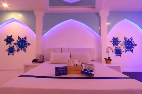 a bedroom with a bed with purple lights on it at Hotel Dreamworld East Ortigas in Manila