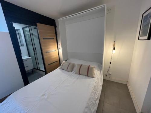 une chambre avec un lit blanc et un miroir dans l'établissement Vue mer au bord des falaises, au Cap d'Agde