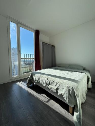 une chambre avec un lit et une grande fenêtre dans l'établissement Superbe Appart de 4 Chambres, Moderne et Spacieux, à Wattignies