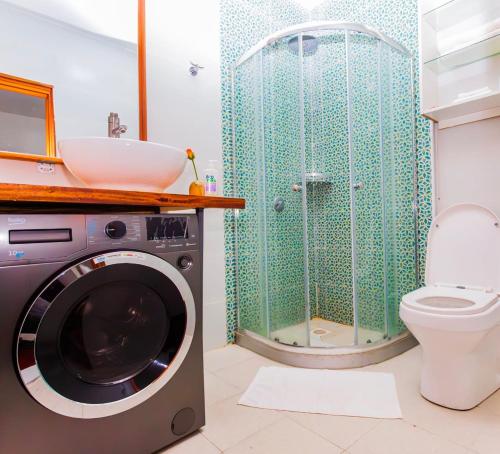ナイロビにあるCaja Apartment A702 at Mango Court Wood Avenue Kilimaniのバスルーム(洗濯機、トイレ付)