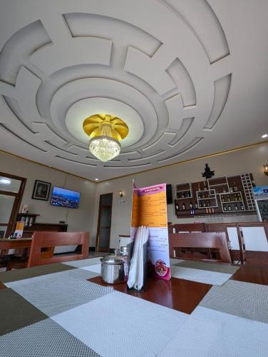 a dining room with a large ceiling and a table at Hotel Meyzieu in Dodoma