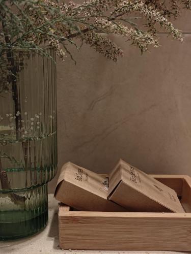 a book sitting on a wooden crate next to a vase at DESERT Ezuz in ‘Ezuz