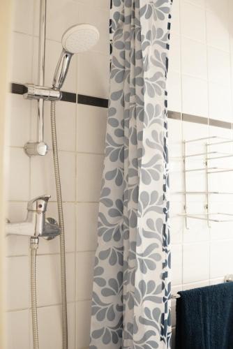 La salle de bains est pourvue d'une douche avec rideau de douche. dans l'établissement Charming comfortable studio, heart of Vauban 513, à Lille