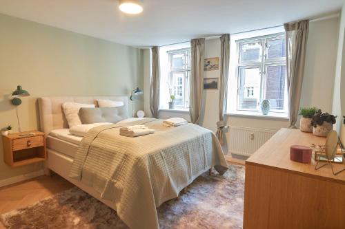 a bedroom with a bed and two windows at Designer 2 BR Home with Private Balcony in Copenhagen