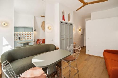 un salon avec un canapé, une table et des chaises dans l'établissement Studio SEVO l Central l Shellter Rentals, à Saint-Tropez