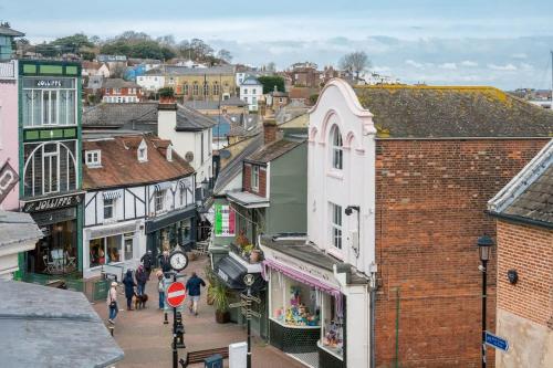 a city with people walking down a street with buildings at Composers apartment in Cowes