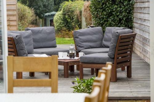 een patio met een bank en een tafel en stoelen bij Firefly House in Cowes