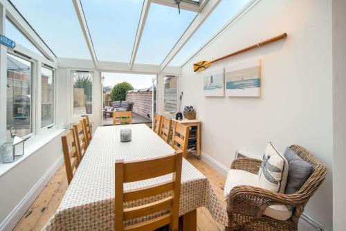 a conservatory with a table and chairs and windows at Firefly House in Cowes
