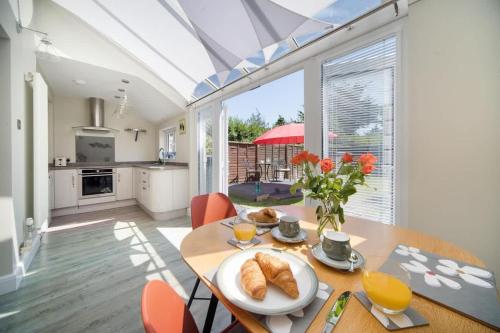 a kitchen and dining room with a table with bread on it at Skysail, Gurnard in Gurnard