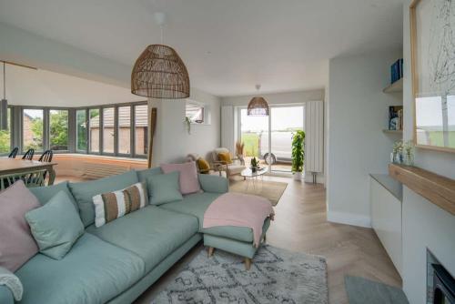 a living room with a blue couch and a table at Spring Hill, Colwell in Freshwater