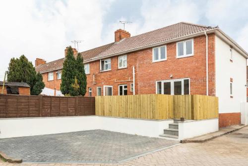 a brick house with a wooden fence at Dings House With FREE Parking In Super Central South West City Location By STAE-Homes in Bristol