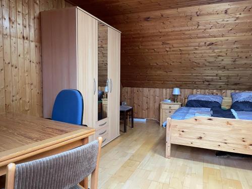 a bedroom with two beds and a wooden wall at Haus der Könige in Wietzendorf
