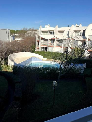 un grand bâtiment avec une piscine devant dans l'établissement Joli studio avec piscine., à La Grande Motte