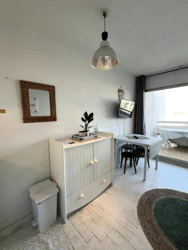 - un salon avec une armoire blanche et une table dans l'établissement Joli studio avec piscine., à La Grande Motte
