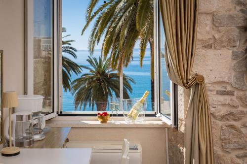 a kitchen with a window with a view of the ocean at Luxury Rooms & Apartment - Main promenade, Sea & City View in Diocletian Palace Split in Split